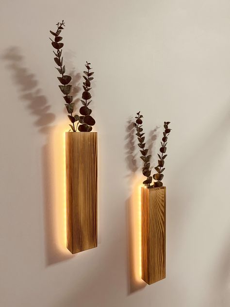 PRICES MAY VARY. BEAUTIFUL LED WALL PLANTER DECORATION – These slim wood wall planters with LED lights and 4 faux eucalyptus stems , and a perfect complement for any wall in your home or office. It will add personality to your gallery wall, bedroom, over the bed, living room, dining room, kitchen, bathroom, indoor patio, bedroom, entry way, dorm or office BOHO DECOR – Each of our wall lights Behind the rustic wooden vase that helps highlight that artificial plants and gorgeous LED lighting. Hang Wall Planter Indoor Decor, Home Decor Lights Living Rooms, Men’s Apartment Decor Modern, Bedroom Decor For Walls, Boho Room Wall Decor, Massage Room Lighting Ideas, Custom Home Decor, Low Lighting Bedroom, Side Wall Decor Living Room