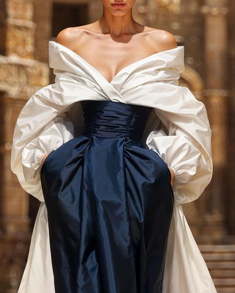 Unveiling the couture taffeta moulage dress, a voluminous off-white gown with an off-shoulder top,a pleated bodice, and a striking blue opal skirt with pockets. Smoothed off with a taffeta over-skirt train for a regal, elegant silhouette. #saiidkobeisy #hautecouture #FW2425 Moulage Dress, Saiid Kobeisy, Off Shoulder Gown, Old Fashion Dresses, Taffeta Dress, Wedding Dress Couture, Pleated Bodice, White Gowns, Skirt With Pockets