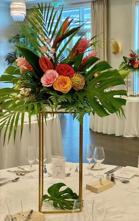 Tall Tropical Centerpiece on gold stand Palm Frond Decor Wedding, Tropical Arrangements Centerpieces, Tall Tropical Centerpieces Wedding, Hawaiian Flower Centerpieces, Tropical Lantern Centerpieces, Diy Tropical Centerpieces Wedding, Birds Of Paradise Centerpiece, Wedding Palm Leaves, Birds Of Paradise Wedding Centerpieces