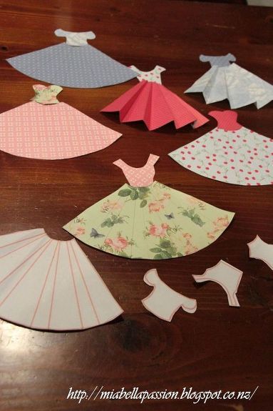 I have always loved these cute paper dresses... and thought I would make a mini bunting of them for my Granddaughter Emilee.   Pattern by Jane CS. is on Mia Bella Passions blog. Jane CS uses her pattern to make the most gorgeous cards.  But I thought they would make a cute bunting.   Cut out the pattern pieces. Use as a template on your pre-chosen pretty papers.   Rules the pleats in pencil.   Cut out the skirt and bodice pieces.   Use  ruler to crease the skirt pleats, and glue bodice… Diy Paper Dress, Make A Paper Flower, Paper Dress Patterns, Bunting Diy, Paper Dresses, Paper Flower Wreaths, Paper Towel Tubes, Mini Bunting, Mesh Wreath Tutorial