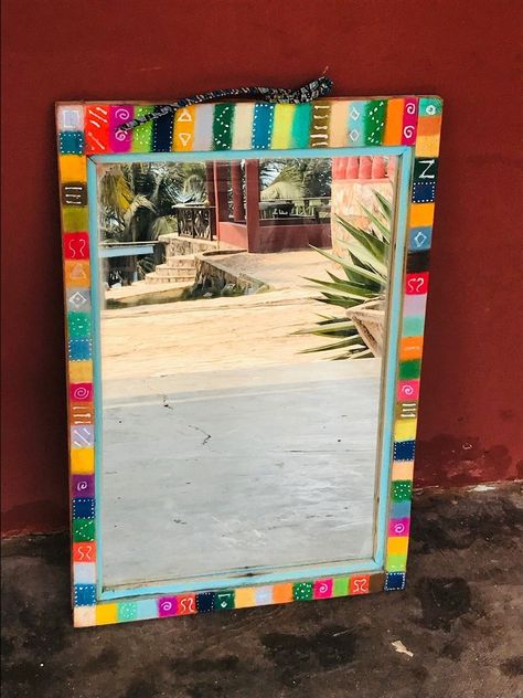 I wanted to try a tribal themed colourful refresh update idea out for a mirror to be hung under cover on my porch to reflect the outdoors and create feeling of more space and this mirror frame was screaming out to be prettified!   I began by choosing some lovely pastels in bright and dark colour combinations and dividing the wood frame into squares or rectangles of colour.   I rub the coloured pigments deep into the wood with my finger   I continue to add the coloured pastels around ed… Painting Mirror Frames Diy Ideas, Diy Rectangle Mirror Frame Ideas, Diy Painted Mirror Frame Ideas, Square Mirror Ideas Diy Paint, Painted Mirror Frame Ideas, Hand Painted Mirror Frame Ideas, Mirror Frame Painting, Funky Painted Mirror Frames, Mirror Frame Painting Ideas