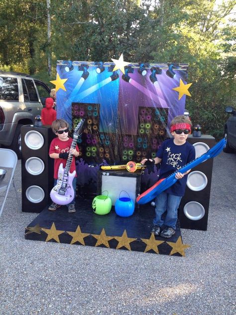 Rock Star Trunk or Treat setup Stage: Pallet & Chipboard, Stars(dollar tree) Backdrop: Scenesetter(Amazon) Speakers: cardboard boxes, spray paint  Instruments/microphones(Party City) Costumes:tees mad using vinyl cut on Cricut, glasses/bandana(Dollar Tree) All the kids had a blast taking turns being Rock Stars. It was very interactive! Dollar Tree Backdrop, Cricut Glasses, Festa Rock Roll, Rock Star Theme, Pop Star Party, Rockstar Party, Tree Backdrop, Rock And Roll Birthday, Music Birthday Party