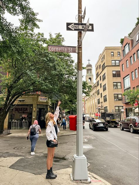 blonde girl in black dress and white button down pointing to Cornelia Street sign in New York City Nyc Apartment Outside, Fashion New York Aesthetic, New York City Taylor Swift, Summer New York Aesthetic, Nyc Ig Stories, Nyc Aesthetic Summer, Nyc Taylor Swift, Summer In New York Outfits, New York Aesthetic Summer