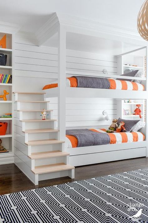 Wooden staircase accents a white bunk bed boasting a shiplap trim lit by white sconces fixed over gray and orange bedding. Modern Bunk, Home With Color, Bunk Bed Rooms, Bunk Beds Built In, Built In Bunks, Bunk Rooms, Bunk Beds With Stairs, Bunk Bed Designs, Kids Bunk Beds