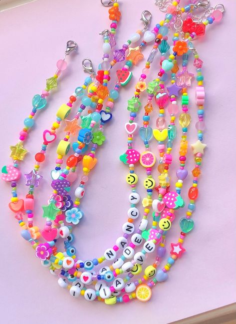 These quirky mismatched necklaces feature multi coloured glass seed beads with random cute charms, such as; stars, hearts, smileys, fruits, flowers, evil eyes & more! Any name/s or word/s up to 12 letters can be added to this necklace, perfect as a personalised gift. Each and every necklace is unique, as they are all made to order. The length is also customisable, just choose your desired length from the drop down box. You can also add an extender chain, so you can wear this necklace at diff Modern Beads Jewelry, Cute Personalized Multicolor Beaded Necklaces, Rainbow Letter Beads Necklace For Summer, Mismatched Necklaces, Cute Beaded Necklaces, Playful Rainbow Beaded Necklaces With Letter Beads, Fun Multicolor Necklace With Letter Beads, Beaded Name Necklace, Multicolor Letter Beads Choker