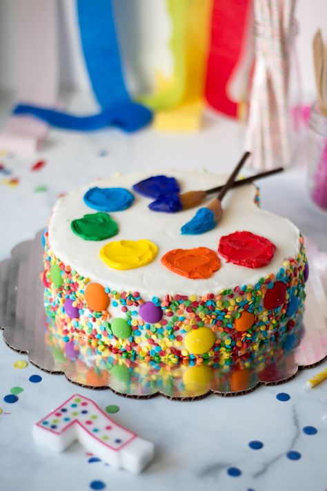 An art Palette Cake for an art themed birthday party! Sprinkled sides with a simple carving of the cake. Frosting ‘paint’ and paint brushes made from pocky cookies and Werther’s soft caramels. #cakedecorating #cakedecoratingfrosting #cake #artcake Paint Brush Birthday Cake, Art Cakes Birthday Artists, Arts And Crafts Themed Birthday Party, Birthday Cake Art Theme, Painter Birthday Cake, Arty Birthday Cake, Artist Palette Cake, Art Themed Birthday Cupcakes, Painting Birthday Cake Ideas