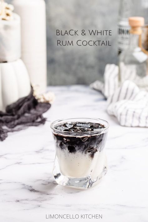 creamy white cocktail in an old fashioned glass with a layer of black on top Black And Gold Drinks, White And Black Cocktail, Black Liquor Drinks, Black And White Drinks Cocktails, Cow Themed Cocktails, Black And White Appetizers, Black Rum Cocktails, Black Mixed Drinks, Oreo Cocktail