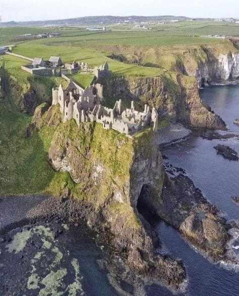 Dunluce Castle, perched dramatically on a cliff overlooking the North Atlantic Ocean in Northern Ireland, is a medieval fortress with a captivating history.  Originally built in the 13th century, the castle is renowned for its stunning and precarious location.  Its strategic position made it a significant stronghold during the medieval period, but it was abandoned in the 17th century due to damage from storms and economic decline.  Dunluce Castle stands as a picturesque and hauntingly beautiful rui Castle By The Ocean, Medieval Traveler, Castles Aesthetic, Castle On A Cliff, Cliff Castle, Ocean Castle, Castle On A Mountain, Midevil Castle, Seaside Castle