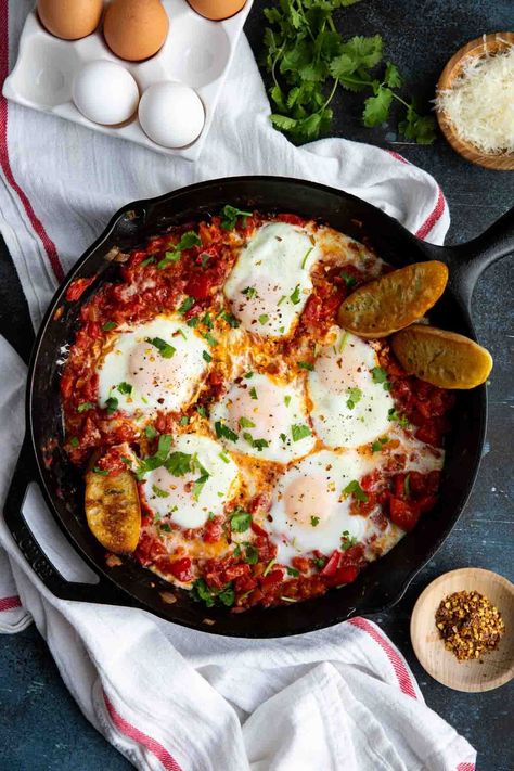 A one pan egg and tomato dish, this Shakshuka recipe, also known as Eggs in Purgatory, is perfect for breakfast or dinner. Serve with some crusty bread for soaking up the runny yolk and delicious sauce. Eggs In Purgatory, Tomato Breakfast, Shakshuka Recipes, Tomato Dishes, Tikka Masala, Evening Meals, Iron Skillet, Cooking Dinner, Skillet