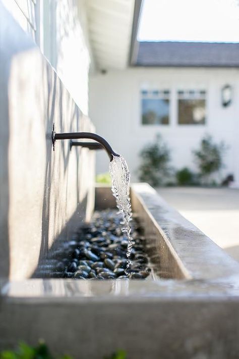 Backyard concrete water feature displaying a row of spigots over river rocks completing a showstopping water fountain. Patio Ideas Concrete, Concrete Water Feature, Fireplace Backyard, Backyard Concrete, Remodel Fireplace, Kitchen Backyard, Backyard Patio Ideas, Boho Backyard, Interior Boho