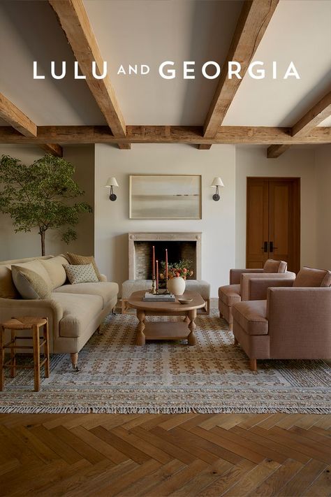 Living room featuring a beige English style sofa opposite of two light pink accent chairs with a light wood coffee table separating them. A fireplace and high ceiling with beams sets the tone for this California English inspired living space. English Style Living Room, Earthy Living Room, Stylish Living Room, Room Remodeling, Living Room Inspo, Decor Living Room, Ideas Home, Living Room Inspiration, Decor Living