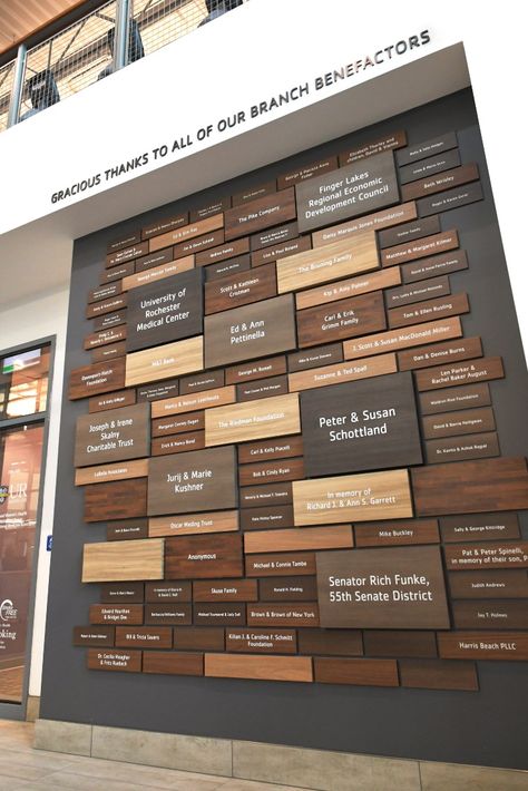 Custom donor recognition wall features woodgrain plaques of various sizes for community center. Donor Wall Design, Donor Plaques, Donor Recognition Wall, Environmental Branding, Recognition Plaques, Food Logo Design Inspiration, Donor Recognition, Donor Wall, Capital Campaign