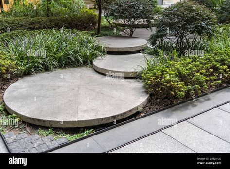 Download this stock image: Round Concrete Steps in the Small Garden. Pathway Between Bushes and Trees. Landscape Design of Sustainable Green Architecture. Stepping Stones at Gre - 2B92NDD from Alamy's library of millions of high resolution stock photos, illustrations and vectors. Sustainable Green Architecture, Grass Centerpiece, Rockery Garden, Stone Pathway, Garden Steps, Concrete Steps, Concrete Garden, Home Garden Design, Green Architecture