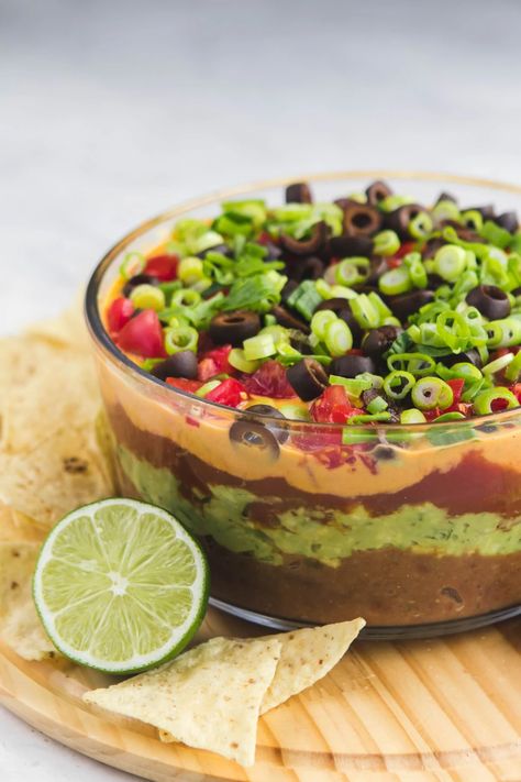 This Vegan Seven Layer Dip is made of layers of Refried Beans, Guacamole, Queso, and more...making it a perfect appetizer or party treat! Gluten Free & Oil Free #vegan #plantbased #dip #partydip #healthyappetizer #appetizer #sevenlayerdip #refriedbeans #guacamole #glutenfree #gameday #potluck via frommybowl.com Vegan Appetizers Recipes, Vegan Potluck, Seven Layer Dip, Vegan Party Food, Vegan Mexican Recipes, Vegan Party, Vegan Dip, Layer Dip, Vegan Mexican