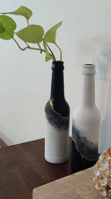 Uttara shared a post on Instagram: ""Kintsugi" is the Japanese art of repairing broken pottery by mending with a mix of lacquer and powdered gold. Inspired by this beautiful art, I present to you these upcycled bottles that will add some class to any corner. I covered the bottles first with chalk paint and then used black and gold @fevicryl_art acrylic paints for the effect. #paintedbottles #bottleart #monochrome #kintsugi #kintsugiart #japaneseinspiration #repurposeddecor #blackwhitegold #bo Black Bottle Painting Ideas, Acrylic Bottle Painting Ideas, Glass Bottle Acrylic Painting, Painting Glass Bottles Acrylic, Glass Bottle Painting Acrylics, Acrylic Painting On Glass Bottles, Glass Bottle Painting Ideas Acrylic, Beer Bottle Painting, Bottle Painting Ideas Acrylics