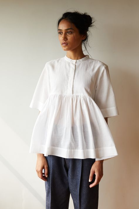 Playful top in pristine white khadi. Partial placket with a single button revealed at the neck. Gentle gathers at the yoke seam. Three quarter length sleeves. Couture, Cotton Short Tops, Cotton Tops Designs, White Summer Tops, Streetwear Inspo, Outfit Board, Handwoven Fabric, Stylish Dress Book, Stylish Girls