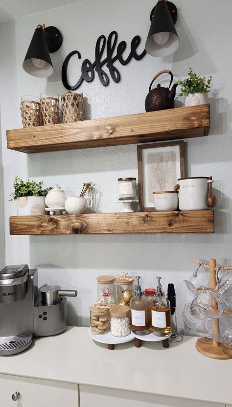 Simple coffee station idea. Neutral theme. Yummy treats perfect for winter and a hot chocolate. Some faux greens to balance it out. Kitchen Floating Shelves Coffee Bar, Coffee Area With Floating Shelves, Olive Green Coffee Bar, Coffee Floating Shelves, Coffee Bar Ideas Floating Shelves, Shelf Decor Coffee Bar, Floating Shelves Coffee Station, Floating Shelves For Coffee Bar, Simple Diy Coffee Bar