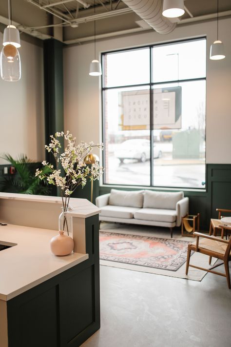 Dental office waiting room in Nashville, TN. #concrete floors #open ceiling #wainscoting #modern #green walls #living room ideas #layered rugs #midcentury Mid Century Waiting Room, Medspa Design Waiting Area, Modern Farmhouse Waiting Room, Cute Waiting Room Ideas, Colorful Dental Office, Welcoming Waiting Room, Dr Office Waiting Room, Boutique Medical Office, Calming Waiting Room