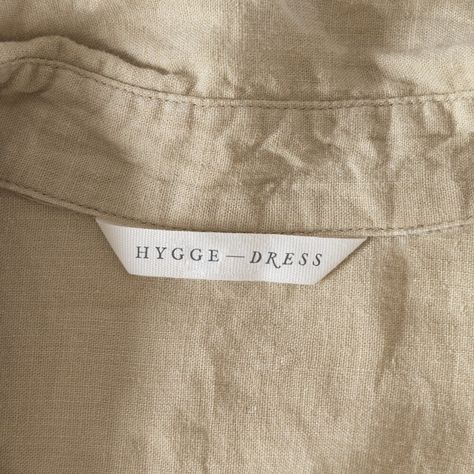 Logo that says Hygge Dress on a white label inside a shirt Couture, Dress Label Tag Design, Apparel Label Design, Linen Branding Logo, Neck Band Design, Clothing Label Inspiration, Clothing Label Design Ideas Branding, Clothing Brand Label Design, Fashion Tags Label Design