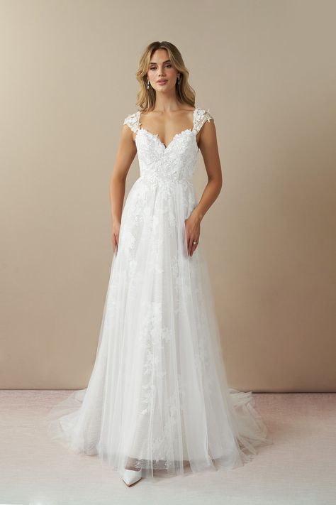 Moonstone is our bridal gown that embodies an ethereal and romantic look. She features a V-neckline with illusion tulle cap sleeves embellished with floral lace applique, that trails down to the A-line skirt with a hint of sparkle. We designed this with a low illusion V-back and a chapel length train for added drama as you walk down the aisle. Elegant Wedding Dress Lace, Wedding Dresses Flowy, Elegant Wedding Dresses Lace, Chapel Train Wedding Dress, Short Sleeve Wedding Dress, Wedding Dress Cap Sleeves, Wedding Dress Flowy, Garden Wedding Dresses, White Champagne