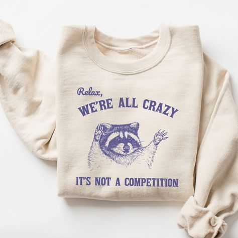 Relax We're All Crazy It's Not A Competition Sweatshirt, Funny Sweatshirt, Vintage Retro Graphic Shirt, Mental Health Shirt, Raccoon Shirt 🧵 HOW TO ORDER   - Pick your size and color from the drop down menus  - Review the sizing and color options in the listing photos  - Add the item to your cart and complete the checkout process  - We'll start working on your order right away! 🧵SIZING  - Please review the listing photos to see the size charts  - These photos will also show you how to order a Raccoon Gift, Sweat Vintage, Raccoon Shirt, Funny Raccoon, Raccoon Funny, Sweatshirt Vintage, Funny Sweatshirts, Graphic Shirt, Looks Style