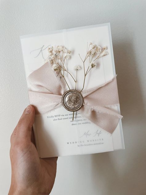 Celebrate your love story with a custom-designed wedding invitation suite that reflects your unique style.  Each suite is meticulously crafted with luxurious vellum wrap, delicate ribbon, a timeless wax seal, and charming baby's breath accents.  Choose your perfect palette from our array of colors for the invitation, ribbon, wax seal, and baby's breath.  Want something truly unique?  We welcome your custom design requests! We'll create a stunning invitation to set the stage for your special day.  A personalized proof will be sent for your final approval before printing. Elevate your wedding stationery with a touch of timeless elegance and personalized charm.         .#WeddingInvitations #DIYWedding #WeddingStationery #WeddingInspiration #WeddingPlanning Vellum Cards Wedding, Old Fashion Wedding Invitations, Vellum And Ribbon Invitations, Wedding Invitation With Vellum Jacket, Wedding Invite Packaging, Wax Seal Wedding Invite, Wax Sealed Wedding Invitation, Wedding Invite Belly Band, Wedding Invitation Wrap