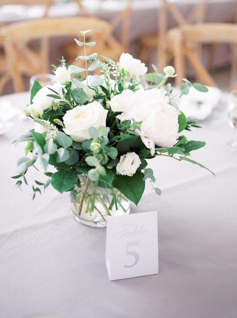 a fresh and stylish wedding centerpiece of various types of greenery, white peonies in a sheer vase is a lovely idea Table Flowers For Wedding, Elegant Wedding Shower Decorations, Small White Flower Centerpieces, Neutral Wedding Floral Arrangements, Elegant Wedding Centerpiece Ideas Round Tables, Small Centerpiece Wedding, Simple Wedding Florals, White Table Flowers, Elegant Wedding Centerpiece Ideas