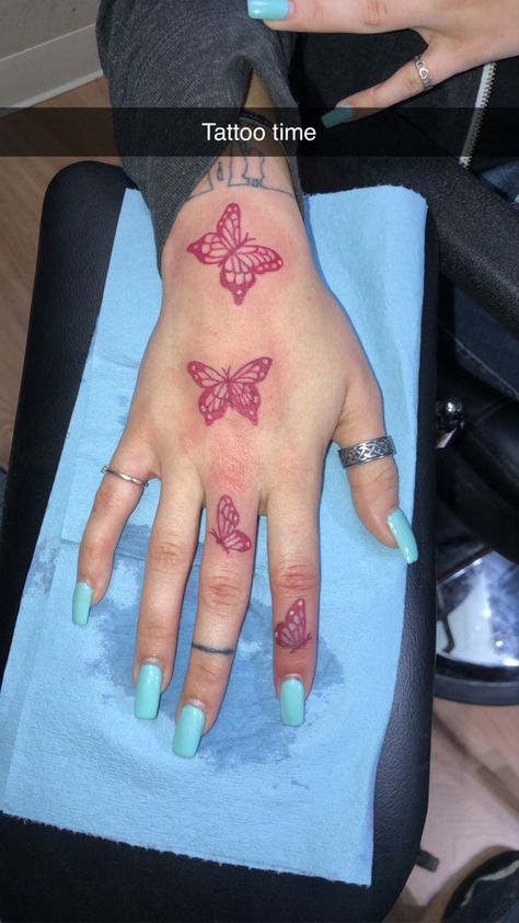 Red butterflies on hand Red Butterfly Hand Tattoo, Red Butterfly Tattoo On Hand, Butterfly Tattoo With Red Ink, Red Butterfly Hand Tattoo For Women, Red Butterflies Tattoo, Tattoo Ideas Female Red Ink, Pink Butterfly Tattoo On Hand, Butterfly Hand Tattoo For Women, Red Ink Tattoos Butterfly