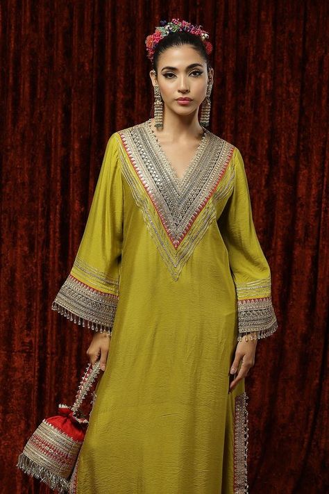 Lemon green woven chanderi silk kurta kaftan with gota, dori, badla embroidery on V neck, bell sleeves and border.
Component: 1
Pattern: Embroidered and Embellished
Type Of Work: Gota, Dori, Badla Work and Crystal Tassels
Neckline: V Neck
Sleeve Type: Bell Sleeves
Fabric: Silk Chanderi
Color: Green
Other Details: 
Crystal tassel details
Fuchsia pink contrast panels
Side slits
Note: The potli bag carried by the model is not for sale
Occasion: Sangeet,Haldi and Mehendi - Aza Fashions Badla Embroidery, Badla Work, Silk Kurti Designs, Kaftan For Women, Stylish Kurtis Design, Pink Contrast, Kaftan Designs, Latest Dress Design, Potli Bag