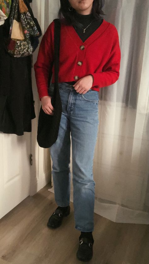 girl standing in a cropped red sweater over turtleneck with blue jeans and black loafers, holding a black tote bag Red Sweater Black Jeans Outfit, Red Sweater Blue Jeans Outfit, Layered Black Turtleneck Outfit, Outfits With Red Turtleneck, Red Sweater Vest Outfits For Women, Red Cropped Cardigan Outfit, Sweater And Loafers Outfit, Turtleneck Cardigan Outfit, Cardigan And Turtleneck Outfit