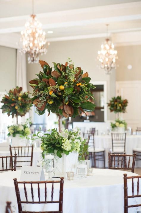 Traditional Wedding at Hotel Ella in Austin Magnolia Arrangements Wedding, Magnolia Centerpiece Wedding, Heavy Greenery Centerpiece, Wedding Decor With Magnolia Leaves, Fruit Tree Centerpiece Wedding, Tall Foliage Centerpiece Wedding, Cocktail Table Tied With Greenery, Green And White Cocktail Table Flowers, Traditional Wedding Favours