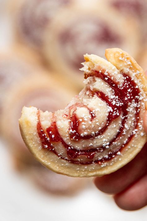 These cream cheese jam pinwheel cookies are airy, light and buttery with a sweet raspberry jam. Cream cheese dough and jam are swirled together to make a beautiful Christmas design. Sprinkle them with a little powdered sugar to look like snow. Jam Thumbprint Cookies Easy, Xmas Pinwheel Cookies, Shortbread Cookie Logs, Cream Cheese Dainties, Christmas Dessert Trays For Party, Jam Filled Snowball Cookies, Raspberry Snowball Cookies, Cinnamon Pinwheel Cookies, Christmas Cookies Slice And Bake