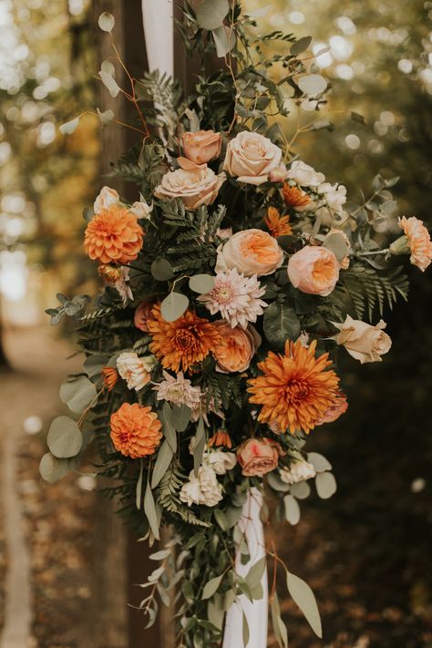 This photo features an outdoor wooden wedding ceremony arch. The right side of the arch has a fresh floral arrangement in the colors blush and orange with some accents of greenery. The flowers are mums, dahlias and roses and the greenery is eucalyptus and leatherleaf. Fall Wedding Aisle Decor, Arch Florals, Mountains Wedding, Wedding Ceremony Arch, Wedding Aisle Decorations, Flower Business, Wedding 2025, Ceremony Arch, Wood Wedding