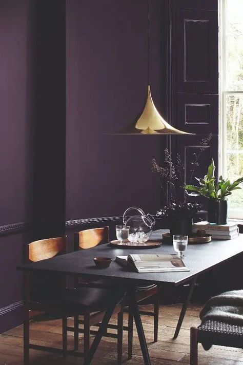 a moody dining room with a deep purple accent wall, a black trestle table and wooden chairs, a shiny gilded pendant lamp Purple Accent Wall, Purple Accent Walls, Deco Violet, Purple Dining Room, Purple Living Room, Dining Room Paint Colors, Dining Room Paint, Purple Rooms, Room Paint Colors