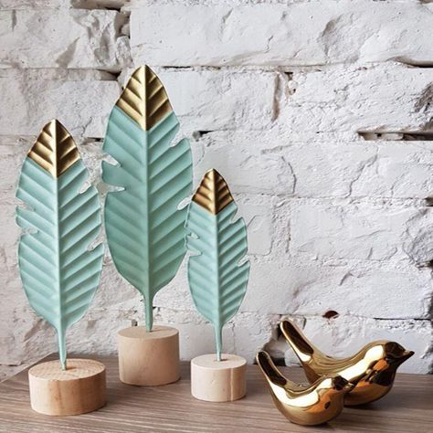 Simple, Modern and Creative - feather figurines make a difference in any space due to the simplistic but effective nature of the design. The small ornament captures a realistic look of a bird's feather. The craftwork done on the designing process is self explanatory as it is of high standards. The golden coloured figurines resemble a luxurious lifestyle that brings comfort as well as a sense of achievement. The wood and Iron materials used for the production are typical materials that you can fi Wooden Feather, Iron Desk, Exposition Photo, Wooden Decorations, Living Room Ornaments, Feather Decor, Flower Nursery, Nordic Home, Decor Figurines