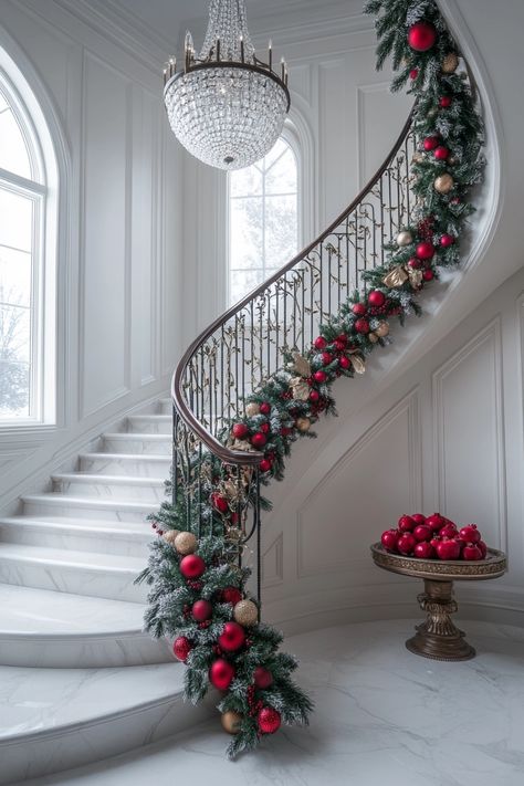 Transform your staircase with lush garlands and vibrant ornaments for stunning Christmas home decor. Elevate your festive spirit with these classic red and gold accents that perfectly complement your elegant space. #ChristmasHomeDecor #FestiveStaircase #HolidayElegance Double Staircase Christmas Decor, Holiday Decor Stairs, Indoor Railing Christmas Decoration, Garland On Bottom Of Staircase, Christmas Bannister Decorations, Christmas Swag On Staircase, Grand Staircase Christmas Decor, Stunning Christmas Decor, Christmas Decoration For Stairs Railings Banisters