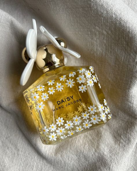 What’s more fitting for bottle painting on @marcjacobsfragrances Daisy than daisies? I wrapped these tiny flowers all the way around the top and bottom borders of the perfume bottle, and on the back, I engraved the beautiful bride’s name and wedding date! The result is truly a one-of-a-kind perfume bottle that’ll be the star of the vanity, bringing back memories of a very special day! 🩵💍✨ #marcjacobsbeauty #marcjacobsperfume #marcjacobsdaisy #daisies #personalizedperfume #customperfume #wedd... How To Gift Wrap A Perfume Bottle, Painting On Perfume Bottles, Painted Perfume Bottles, Wedding Parfum, Aesthetic Perfume Bottles, Perfume Bottle Painting, Perfume Art Painting, Wine Shoot, Flower Perfume Bottle