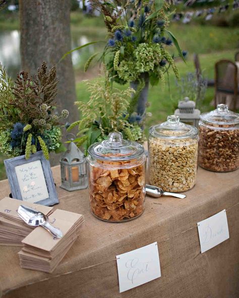 Salty Snacks Before guests arrived at the ceremony, pre-ceremony snacks like Old Bay-seasoned potato chips, spiced nuts, and dilled oyster crackers were set out on a table with paper bags and scoops so guests could help themselves. Chips At Wedding, Sweet And Salty Table Wedding, Late Night Snack Table Wedding, Outdoor Snack Bar, Easy Wedding Snacks, Chip Buffet, Ceremony Snacks, Wedding Table Snacks, Rehearsal Dinner Etiquette