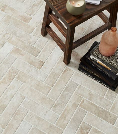 Floor featuring 3x12-inch porcelain subway tile arranged in a herringbone pattern. Arranging the light gray, brick-look tiles in this pattern creates a sense of movement that extends across the entire floor. Cream Tile Floor, Brick Tile Floor, Herringbone Tile Floors, Entryway Tile, Mudroom Flooring, Rich Character, Brick Look Tile, White Subway Tile Backsplash, Matte Tile