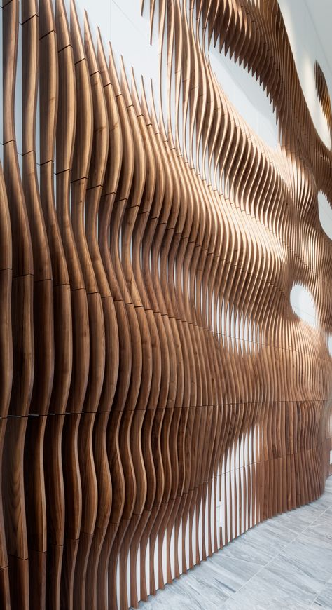 We designed, produced, and installed this parametric walnut slat wall for hte lobby of a residential development in Austin, TX.  The piece is made up of 209 wall panels and over 1500 Walnut wood slats. Walnut Slat Wall, Tv Fal, Wooden Facade, Interactive Walls, Wood Slat Wall, Residential Development, Parametric Architecture, Wood Cladding, Parametric Design