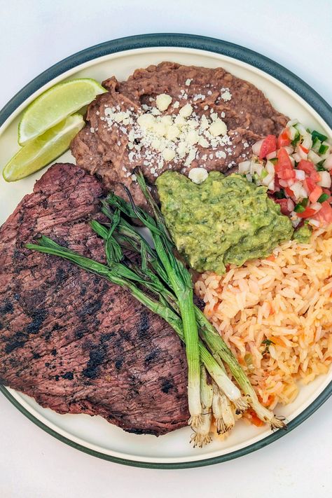 Make your own restaurant-style carne asada platter with perfectly grilled steak, rice, refried beans, guacamole, pico de gallo, and seared vegetables. Steak Rice And Beans, Carne Asada Rice And Beans, Ranchera Meat Recipes, Mexican Carne Asada Party, Carne Asada Plate, Carne Asada Meals, Cozy Brewery, Carne Asada Aesthetic, Carne Asada Party