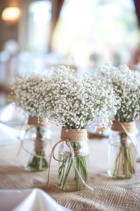 Using Mason Jar Centerpieces to Add Color to Your Table Settings Diy Baptism Centerpieces, Classic Wedding Centerpieces, Jar Centerpiece Wedding, Mason Jar Flower Arrangements, Jar Flowers, Wedding Centerpieces Mason Jars, Mason Jar Centerpiece, Rustic Wedding Table Decor, Baby Shower Table Decorations