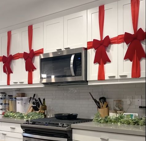 Decorating your kitchen for Christmas 🎄 Red Bow On Kitchen Cabinets, Red Ribbon On Kitchen Cabinets, Christmas Decoration Kitchen Cabinets, Cabnit Christmas Bow, How To Decorate Top Of Kitchen Cabinets Christmas, Brown Cabinet Christmas Decor, Christmas Decor Small Kitchen, Christmas Decor Ideas Renter Friendly, Kitchen Cabinet Ribbon Christmas