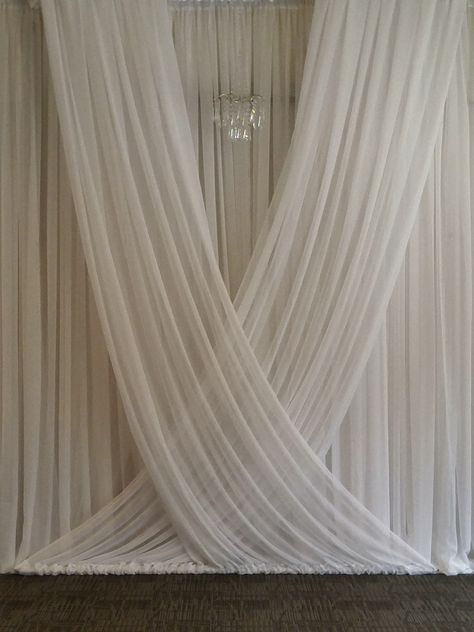 We created this gorgeous flowing backdrop for a wedding ceremony at the Royal Glenora Club in Edmonton, AB.  #weddingbackdrop #wedding ceremony #weddingceremonyideas #weddingceremonyinspiration Draped Alter Wedding, White Curtain Wedding Backdrop, Fabric Wedding Ceremony Backdrop, Drapes For Wedding Ceremony, Backdrop With Chandelier, Wedding Drapes Backdrop, Fabric Ceremony Backdrop, Wedding Ceremony Draping, Wedding Drapery Ideas