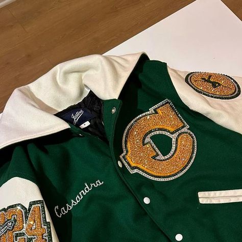 Mrs. Erica 💖 on Instagram: "Varsity dance team letterman jacket for Canyon High School! 💛💚✨✨✨💎 #LettermanJacket #BlingedLettermanJacket #VarsityCheerleader#Cheerleading #VarsityJacket #Cheer #Cheerleader #Varsity #HighSchoolCheer #Dance #DanceTeam #VarsityDanceTeam #VarsityDancer" Varsity Cheer Jacket, Cheer Varsity Jackets, Letterman Jacket Senior Pictures, Cheer Letterman Jacket, High School Letterman Jacket, Black Letterman Jacket, Letterman Jacket Ideas, Cheer Jackets, Letterman Jacket Outfit