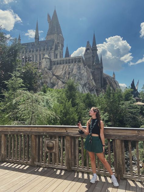 Picture of a girl wearing a black top and green skirt with white tennis shoes on a bridge at Harry Potter world in Universal Studios in front of Hogwarts Universal Slytherin Outfit, Harry Potter Disney Outfit, Slytherin Universal Outfit, Slytherin Outfit Universal Studios, Universal Hogwarts Outfit, Outfits For Harry Potter World, Summer Universal Studios Outfits, Harry Potter Outfits Summer, Harry Potter Theme Park Outfit