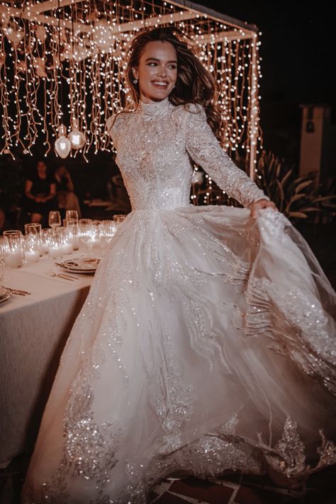 Sparkly, fully adorned wedding ball gown. Features a turtleneck bodice, semi-transparent crystal beaded long sleeves, and a full skirt with a train. Turtleneck Bride Dress, Full Lace Wedding Dress With Sleeves, Ball Gowns Full Sleeve, Princess Winter Wedding Dress, Full Sleeves Wedding Gown, Magical Long Sleeve Wedding Dress, Wedding Dress With A Collar, Long Sleeve Full Skirt Wedding Dress, Long Sleeve Turtleneck Wedding Dress