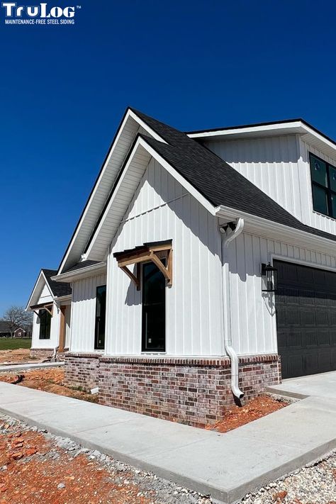 Modern Farmhouse Exterior Colors White, White Hardie Board With Brick, White Farmhouse Brick Foundation, Black And White Farmhouse Exterior With Brick, Brick And Board And Batten Exterior Ranch, Brick And Metal Siding Exterior, White Metal Siding Farmhouse, White Garage Exterior, Black And White Double Wide Exterior