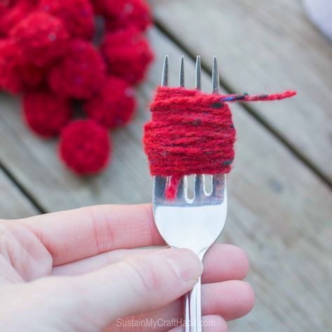 Red yarn would around a fork to create a DIY pom pom garland #christmas-crafts #decor #driftwood-crafts #garland #mantel #mantle #pompoms #scrap-yarn #yarn #yarn-projects#christmas-crafts #knitting-and-crochet-patterns #valentines-day-drafts #sustainmycrafthabit Christmas Garland Diy Yarn, Yarn Decorations Christmas, Easy Yarn Christmas Ornaments, Christmas Pompom Garland, Diy Wool Christmas Decor, Diy Christmas Pom Pom Garland, Christmas Yarn Garland Diy, Yarn Ball Garland, Diy Christmas Decorations With Yarn