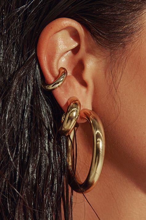 Any outfit, every day, all occasions. Sculpted in a two-inch arc, our 18K gold filled hoops are the style that unites true hoop girls and those who just dabble in the art. Wear solo or alongside other hoops in a graduating stack. Jewelry Collection Handcrafted in Brazil 18k Gold Filled Thickness: 7mm Diameter: 2" Weight: 0.55 oz Waterproof Hypoallergenic.#jewelrylover #handcraftedjewelry #jewelryinspiration #jewelrydesign #jewelryobsessed #jewelryoftheday #jewelrygoals #jewelryfashion #jewelrytrends Gold Hoop Earrings Aesthetic, Stack Jewelry, Chunky Gold Jewelry, Thick Gold Hoop Earrings, Dope Jewelry Accessories, Thick Hoop Earrings, Earrings Aesthetic, Luxe Jewelry, Earring Designs